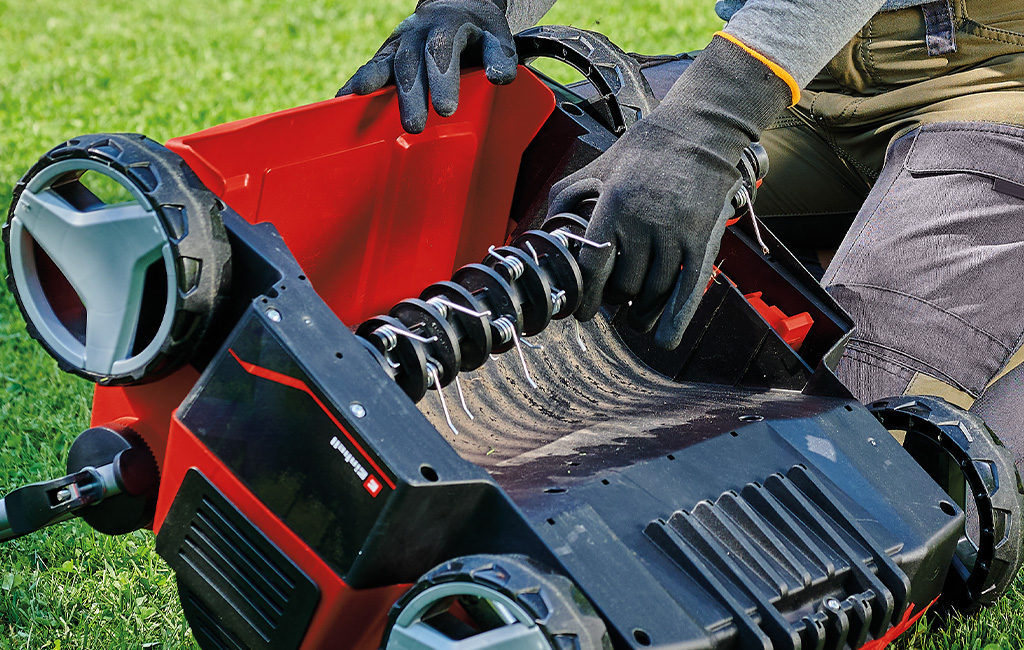 Someone attaching a fan roller to an Einhell scarifier aerator.