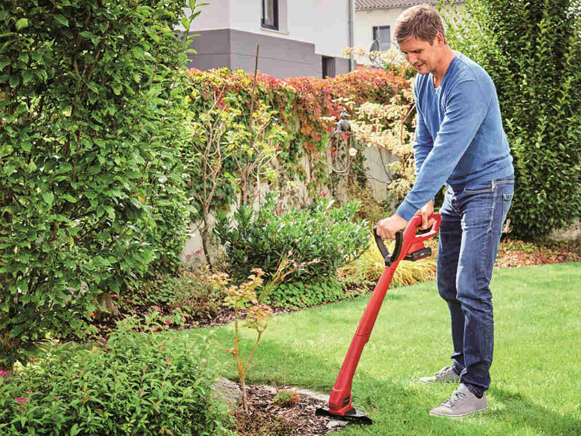 man trimming on the stone next to the grass