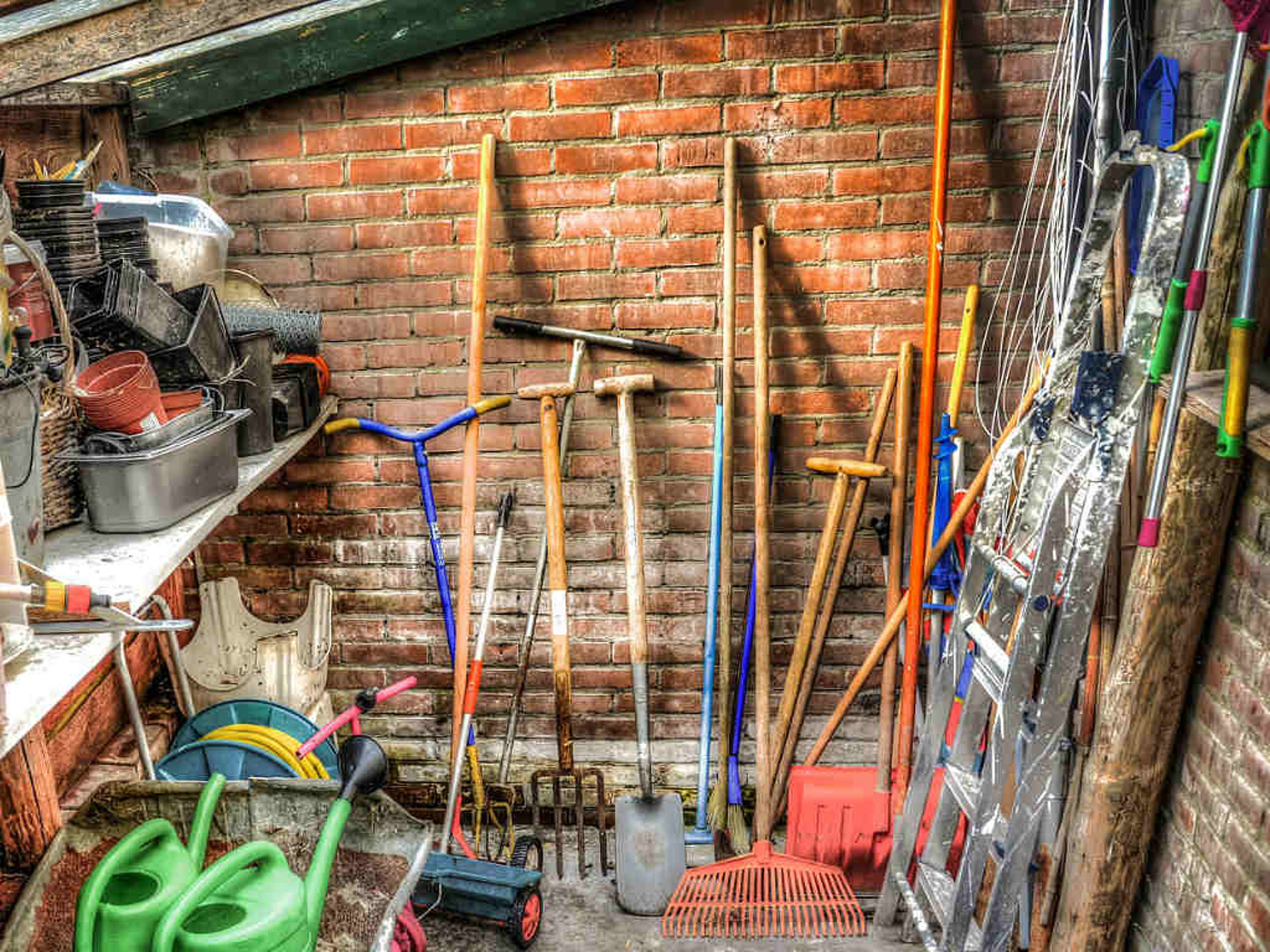 A shed with lots of garden tools.