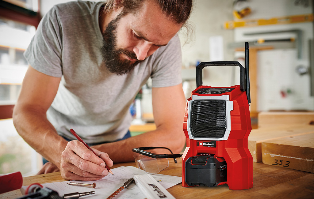 A man is listening to music on the einhell cordless radio