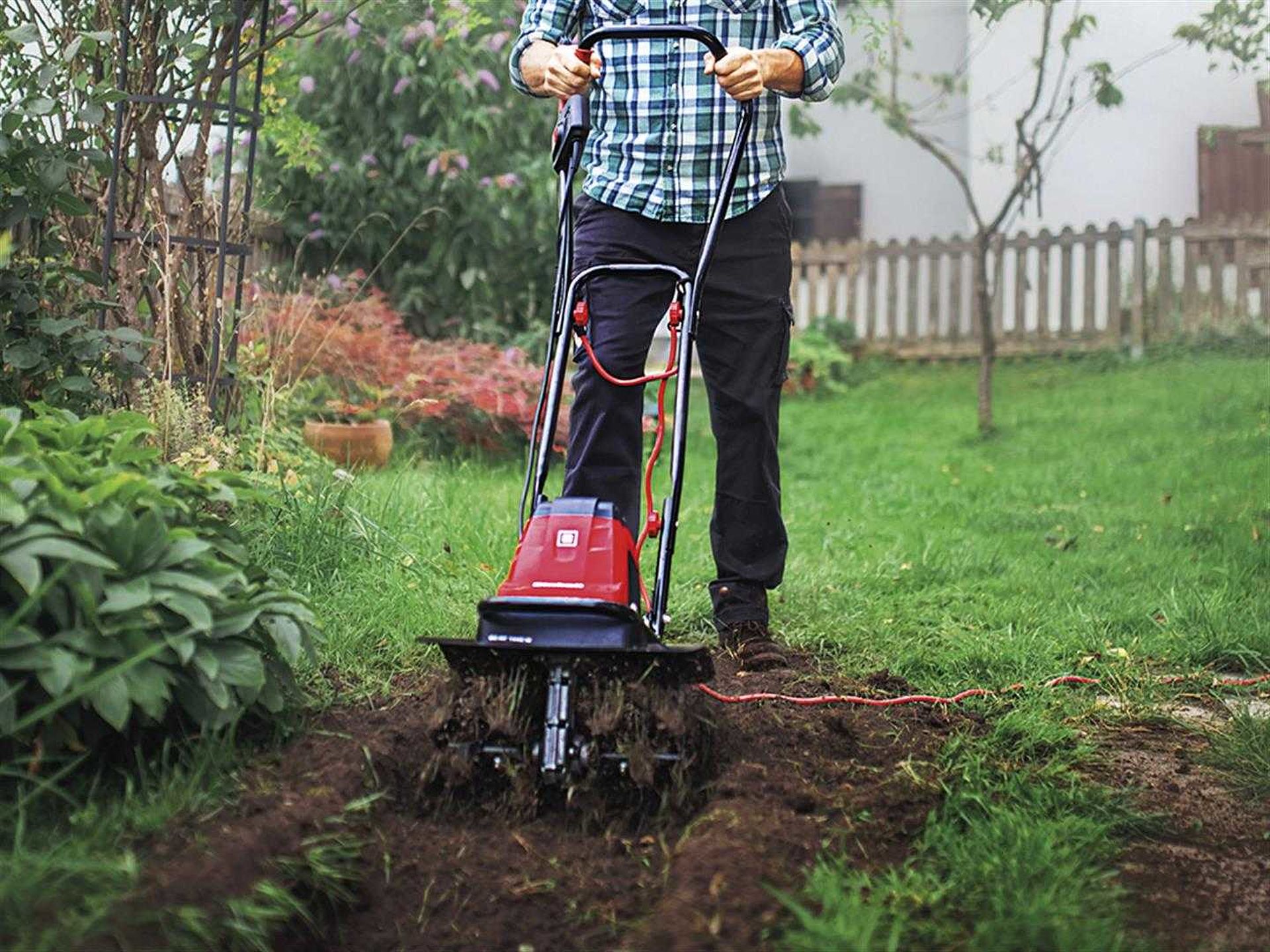 a man prepares his soil with a soil hoe