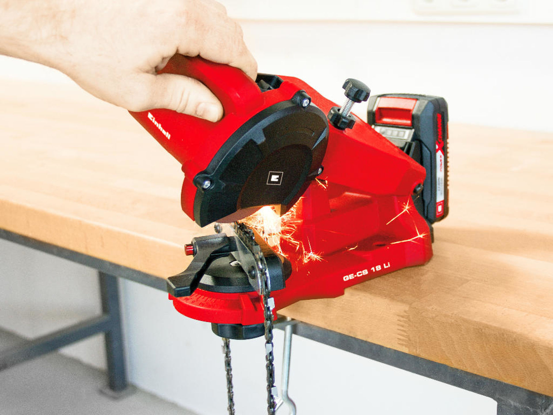 A man is sharpening a saw chain.