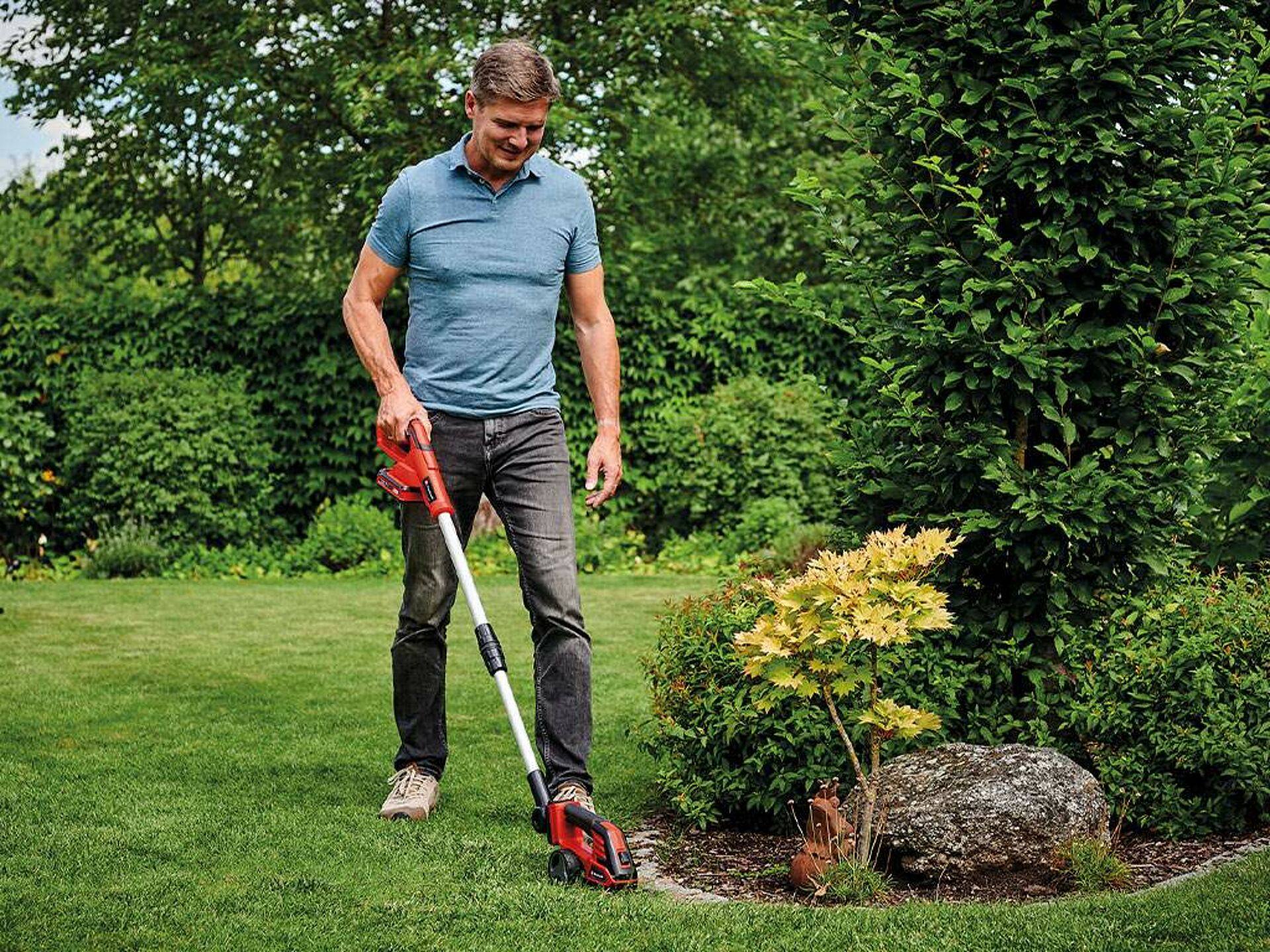 a man trims the lawn edge