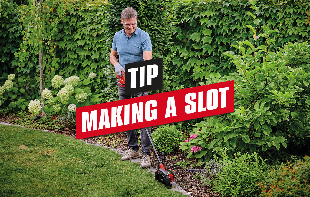 a man is trimming edges with the Einhell cordless lawn edge trimmer | text: tip: making a slot