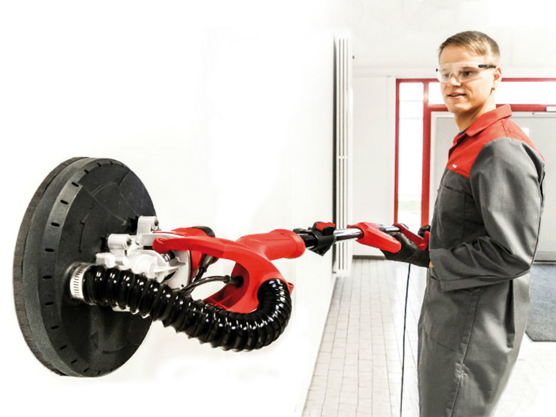 man grinds the wall with a retractable grinder