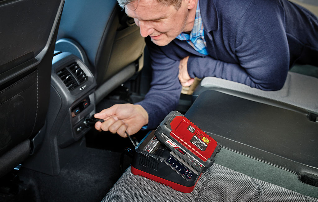 a man is using the Einhell Car charger in a car