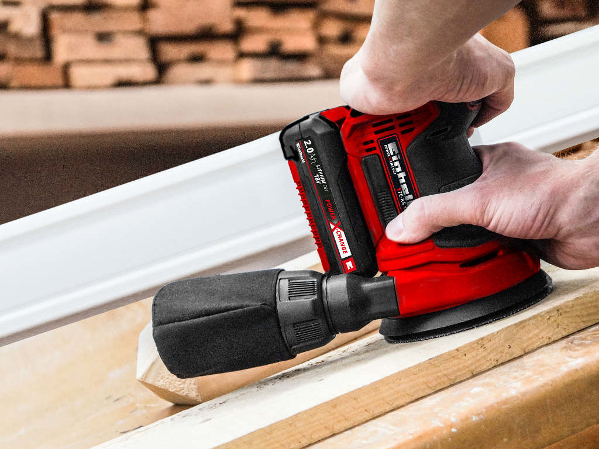 a wood is sanded with a round sander