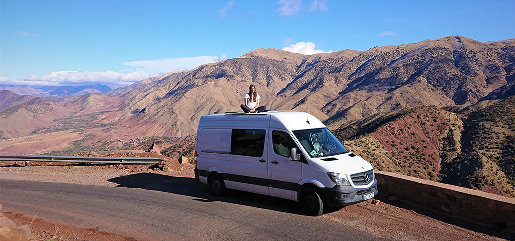 woman sitting on van roof