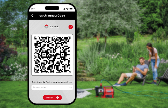 Ein Smartphone zeigt die QR-Code-Scanner-Funktion der Einhell-Connect-App, im Hintergrund eine Pumpe im Garten.